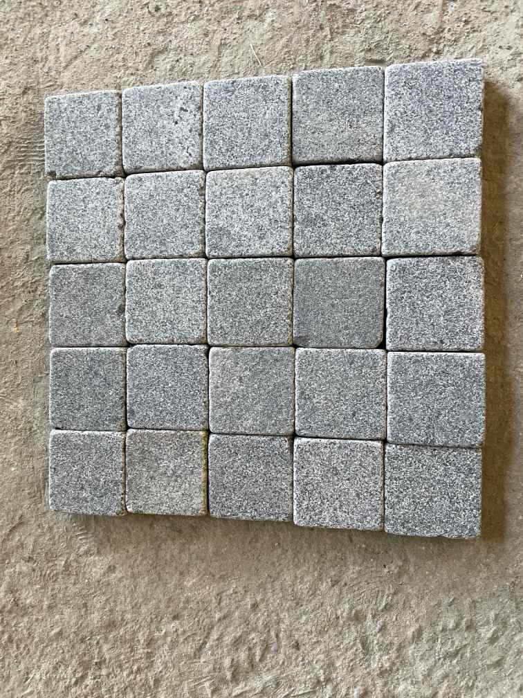 Cambodian G654 dark grey granite showing a flamed top and lightly brushed exposed edge.