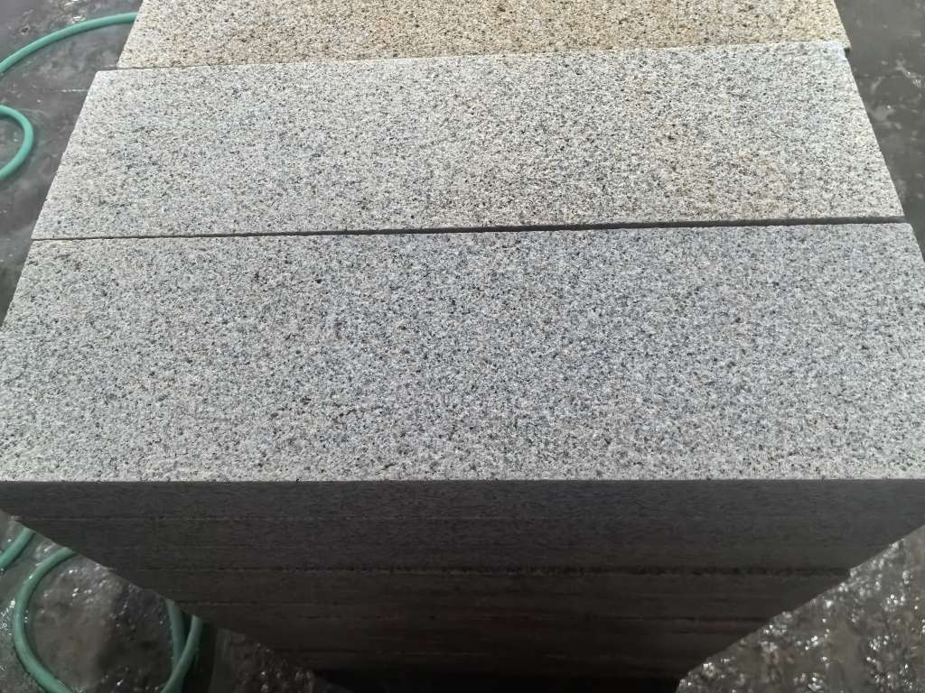 Flamed granite pavers installed across a commercial plaza or public pedestrian area.